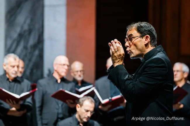 Jacques Charpentier dirigeant les choristes du Groupe Vocal Arpège en concert